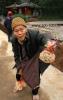 Пожилая китаянка предлагает туристам арахис, фото