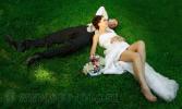 Молодожены лежат на траве, свадебная фотография