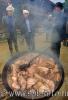 Мясо свиньи варится в котле, идет пар, сквозь который видны мужчины этнического меньшинства Мяо, проживающие в селе Zengchong (&#22686;&#20914;), провинции Гуйчжоу, в Юго-Западном Китае