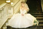 Невеста сидит на ступенях парадной лестницы Кировского ЗАГСа в Санкт-Петербурге