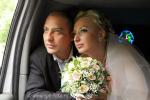 Жених и невеста выглядывают из окна лимузина, фото
