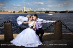 Свадебное фото, жених и невеста присели на цепь ограждения причала "Зимняя канавка"