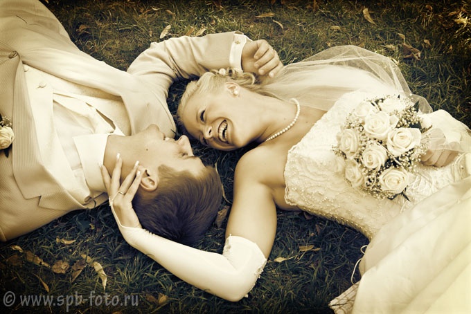 Свадебная фотосессия на газоне (молодожены лежат на траве)