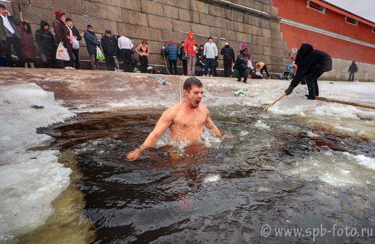 People gather around a bath of ice cold water while celebrating Epiphany at the St